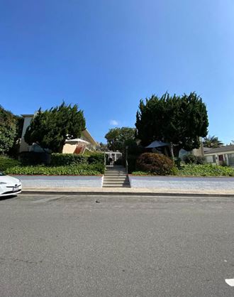 a street view of a house with a driveway and stairs