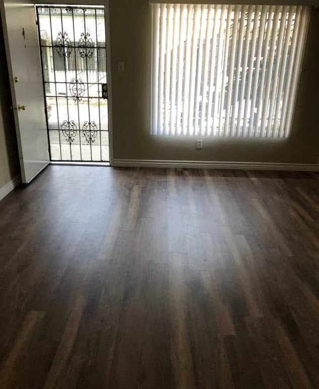 a living room with a wood floor and a glass door