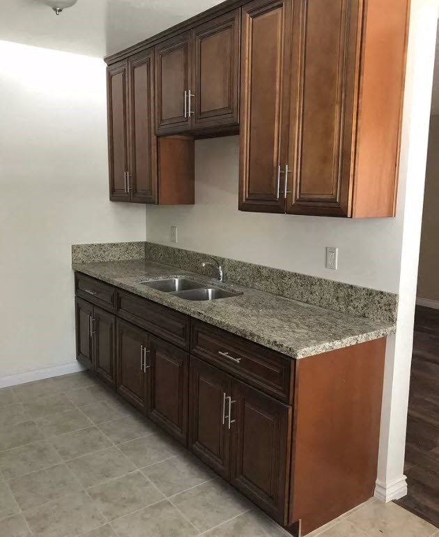 a kitchen with wooden cabinets and granite counter top and a sink