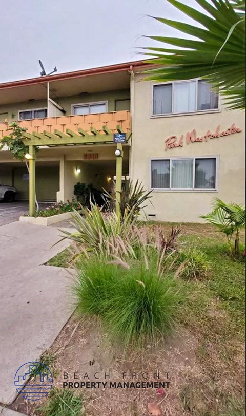 a building with a porch and a palm tree in front of it