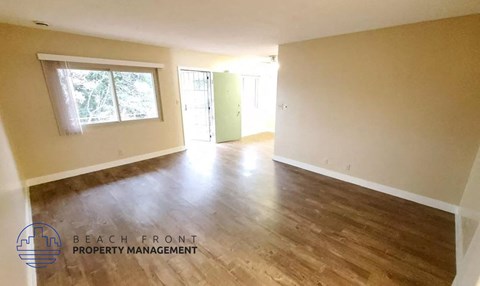 the living room and dining room of an empty house with wood floors