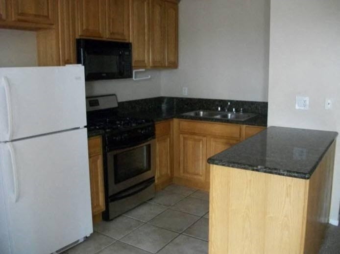 a kitchen with a stove refrigerator and a sink
