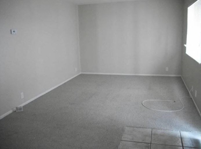 an empty room with a carpeted floor and a window