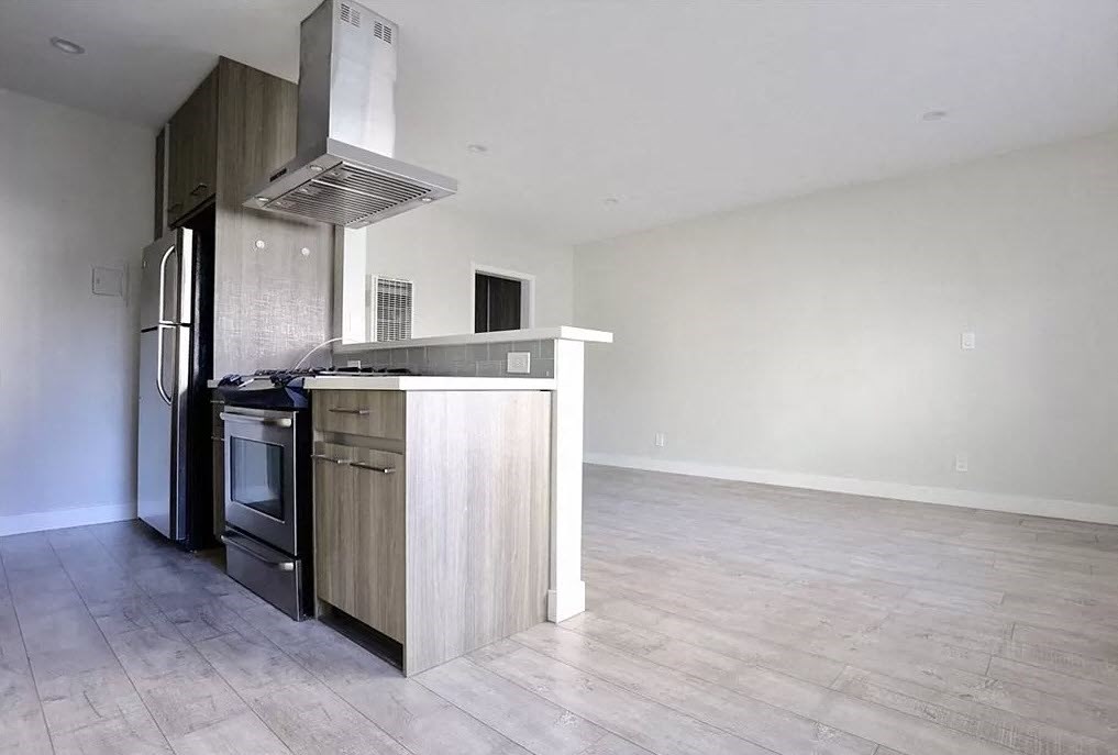 an empty kitchen with a stove and a refrigerator