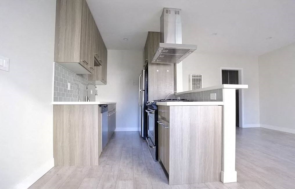 an empty kitchen with a stove and a refrigerator