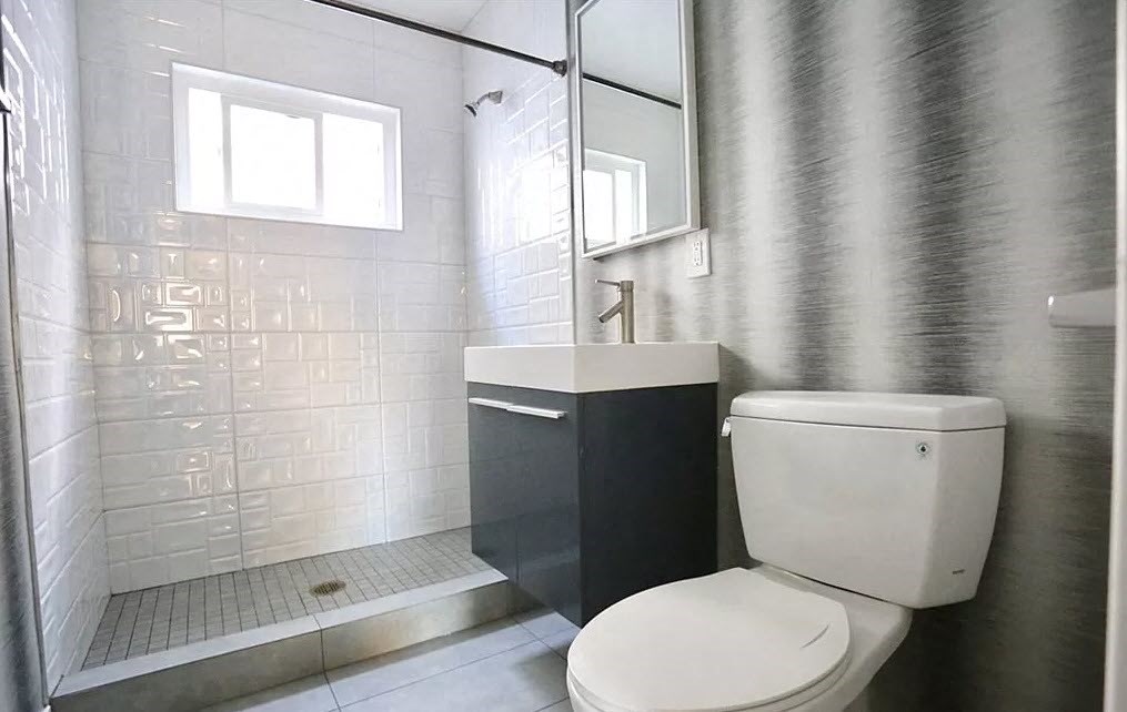 a bathroom with a toilet and a sink and a shower