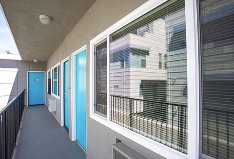 a long hallway with windows and blue doors
