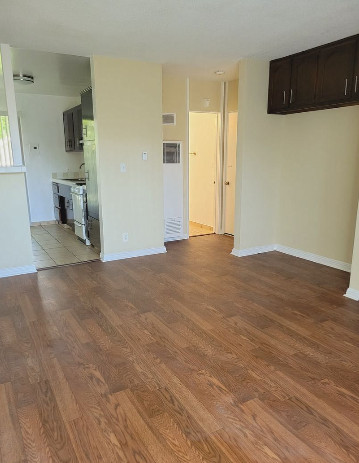an empty living room with a hard wood floor