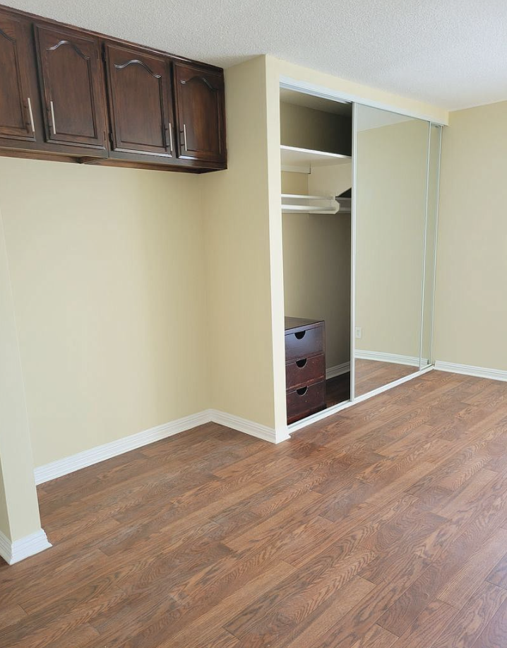 an empty room with wooden floors and a closet