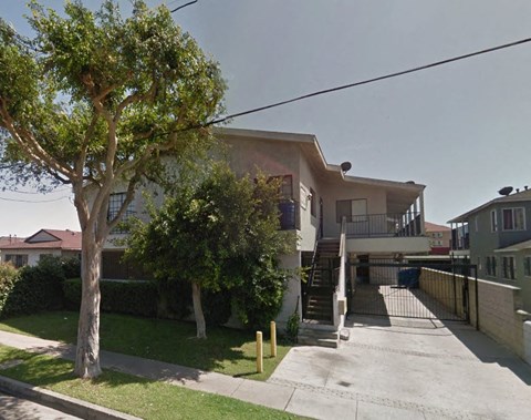 a house with a driveway and a tree in front of it