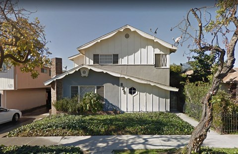 A two-story house with a white exterior and a grey roof.