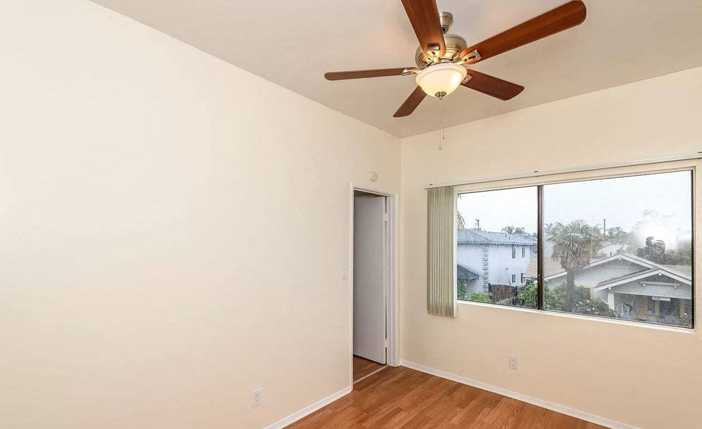 a living room with a ceiling fan and a large window