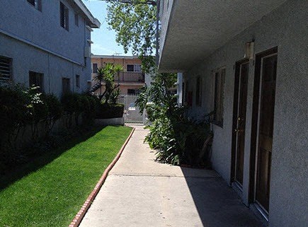 A long concrete walkway leads between two buildings.