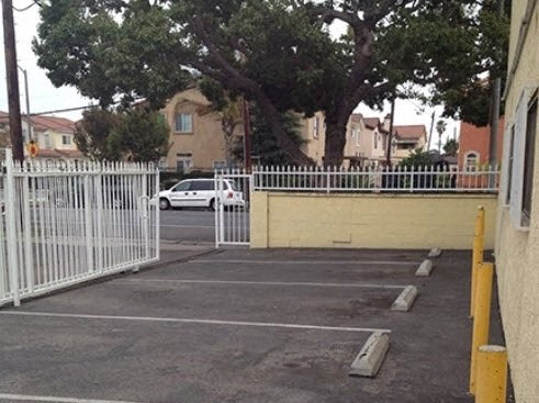 a parking lot with a white fence and a tree