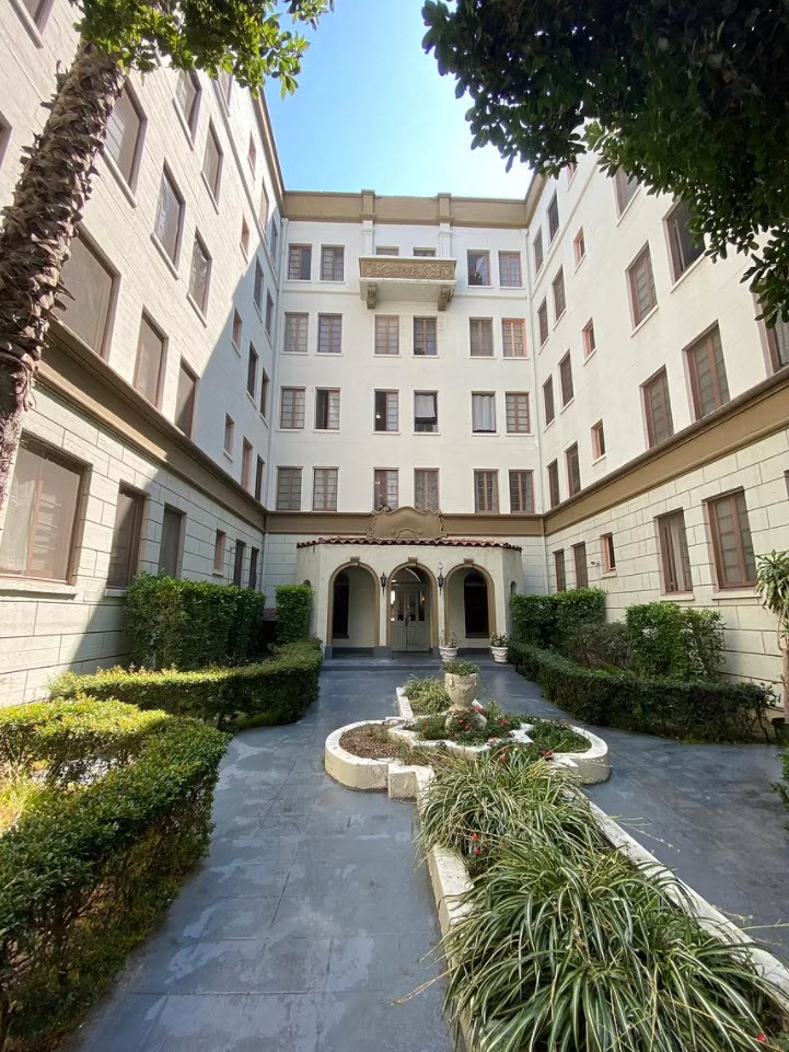 a courtyard with a fountain in front of a building