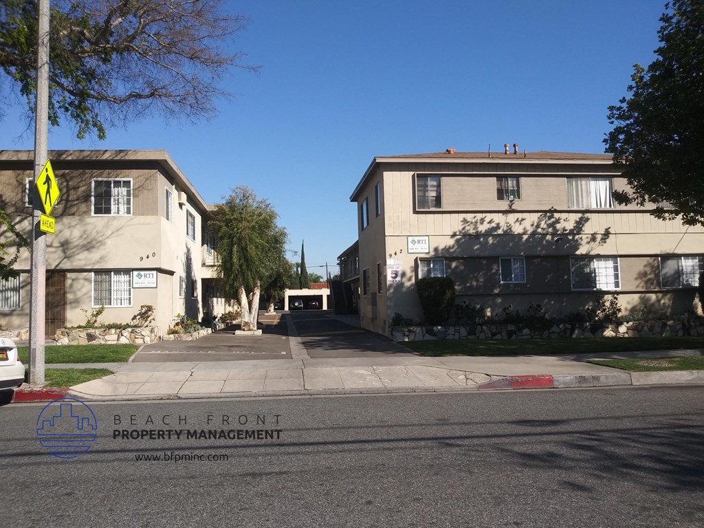 a street view of two apartment buildings on the corner of a street