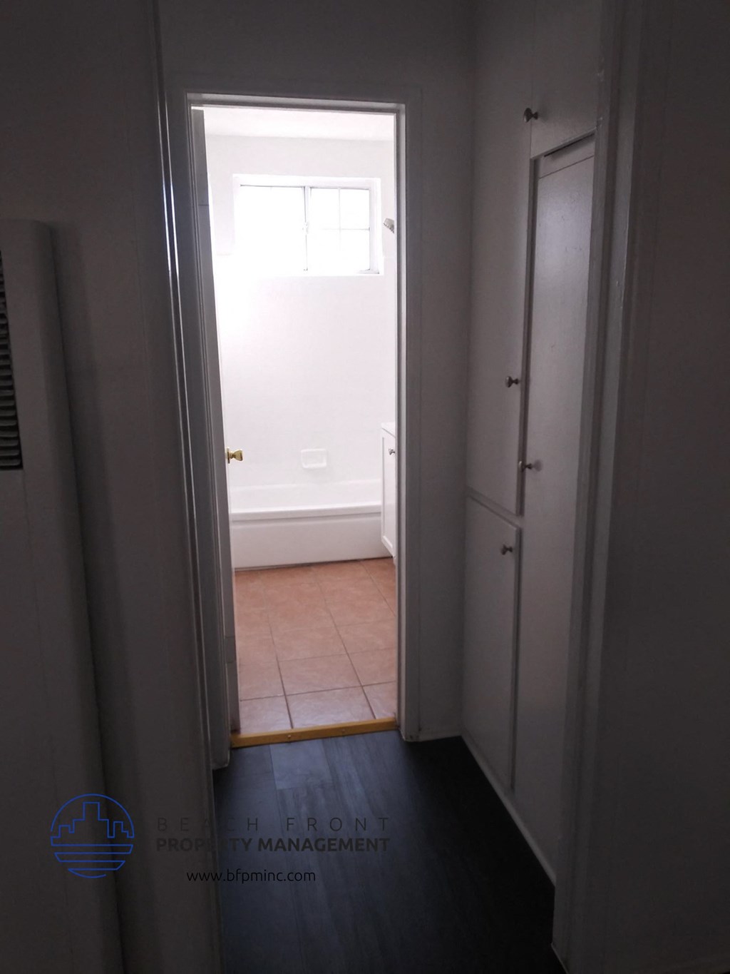 a room with a door open to a bathroom and a window