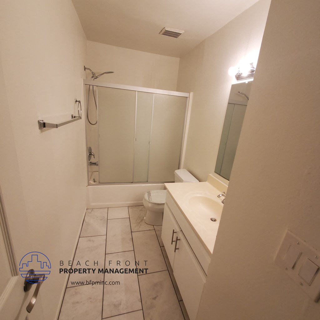 a small bathroom with a white sink and toilet and a shower with a glass door