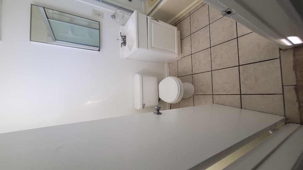 a small bathroom with a toilet and a sink and a window