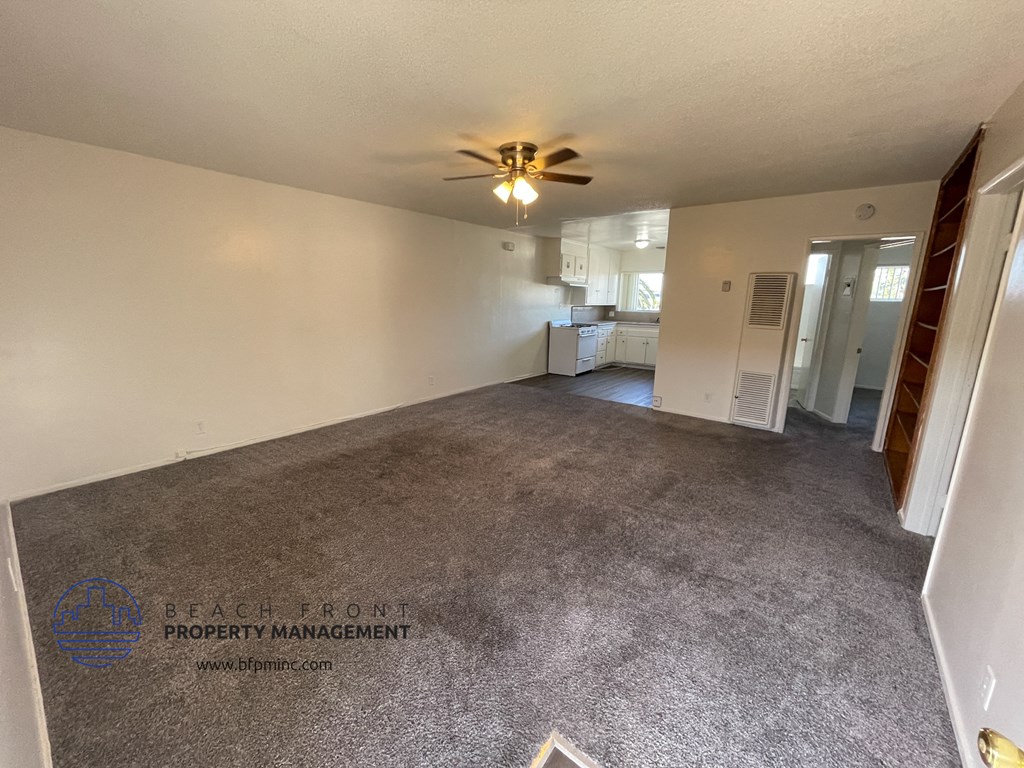 the living room of an empty house with a ceiling fan