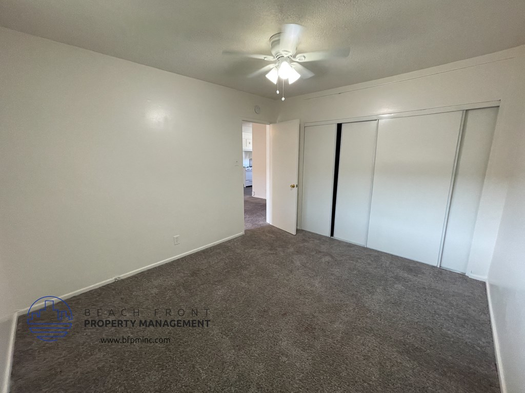 a bedroom with a carpet and a ceiling fan