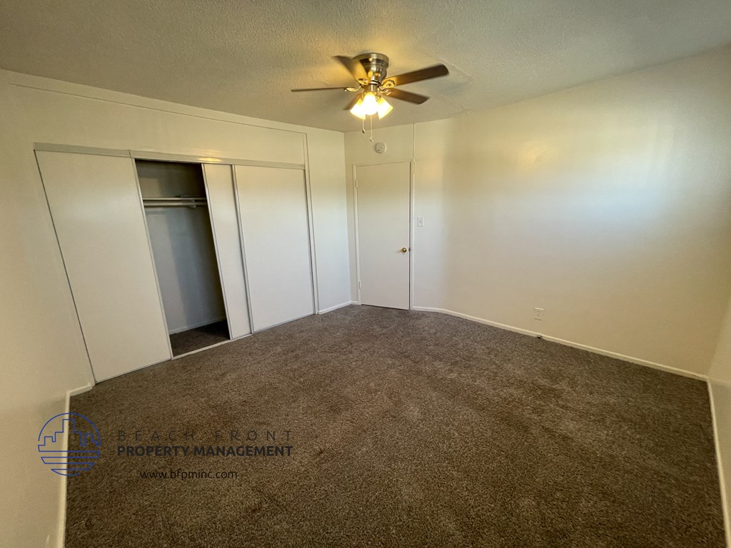 a room with a carpet and a ceiling fan