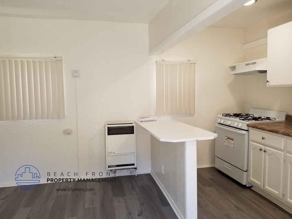 a kitchen with white cabinets and a sink and a stove and a refrigerator
