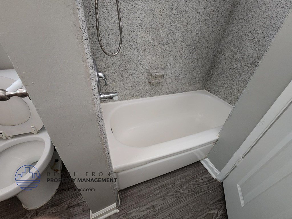 a bathroom with a white tub and a toilet