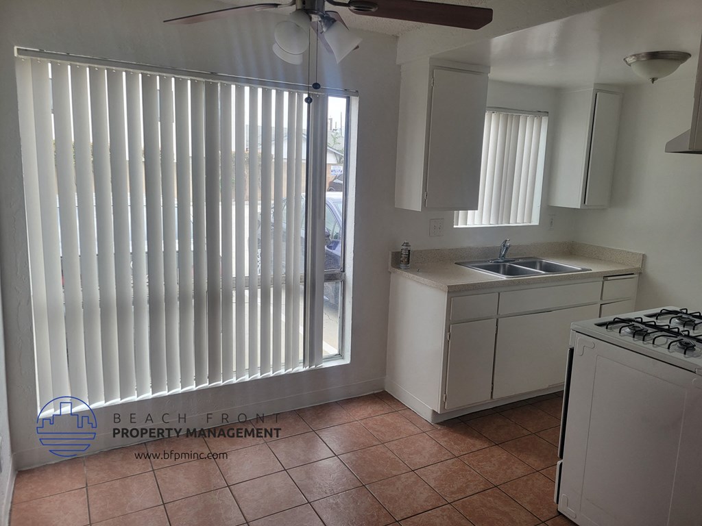 a kitchen with a sink and a window with white blinds
