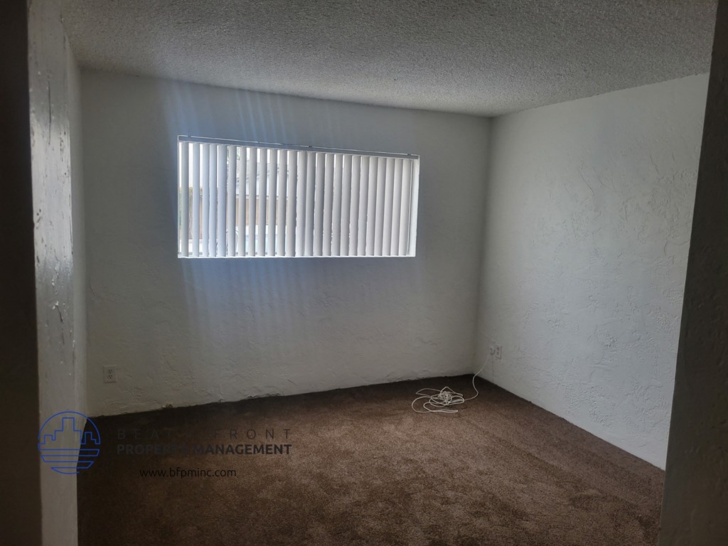 an empty room with a window and a carpet