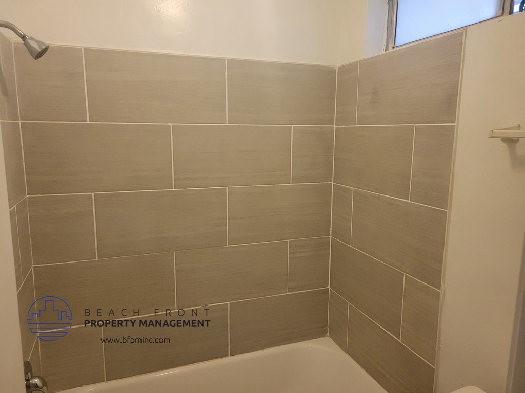 a small bathroom with a shower and a bath tub