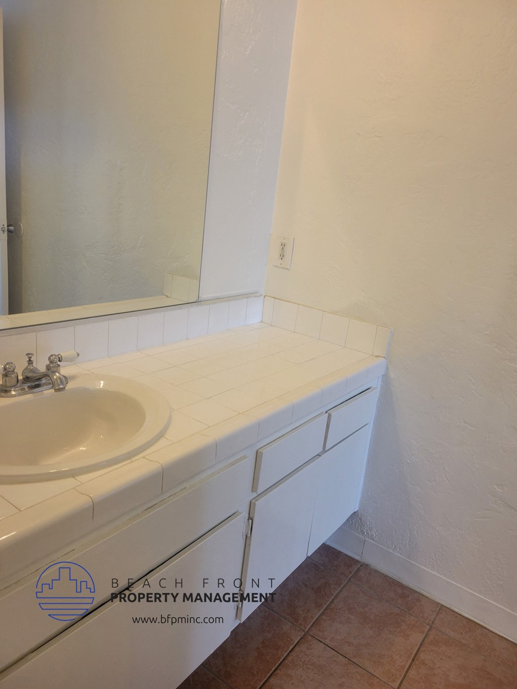 a white bathroom with a sink and a mirror