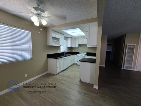 a large kitchen with white cabinets and black counter tops