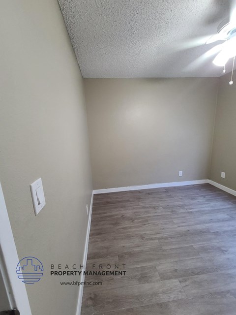 a empty room with a wood floor and white walls