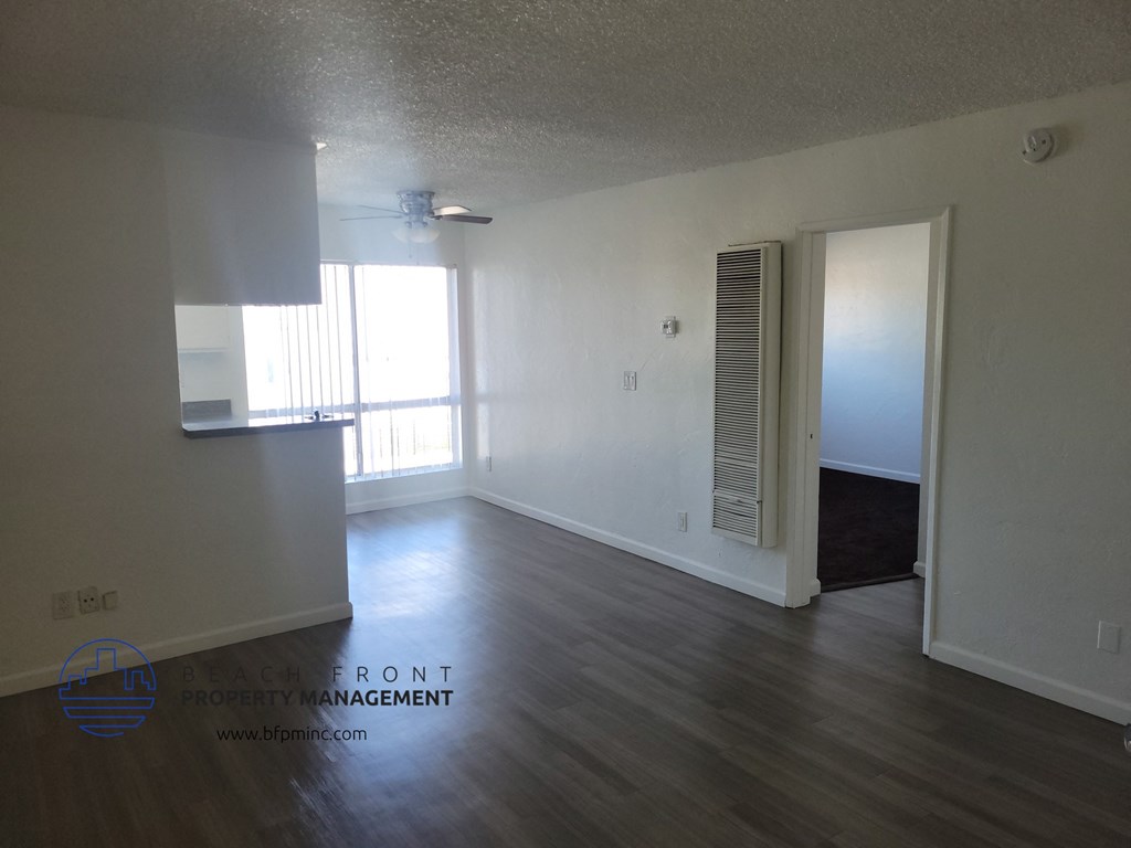 an empty living room with wood floors and white walls