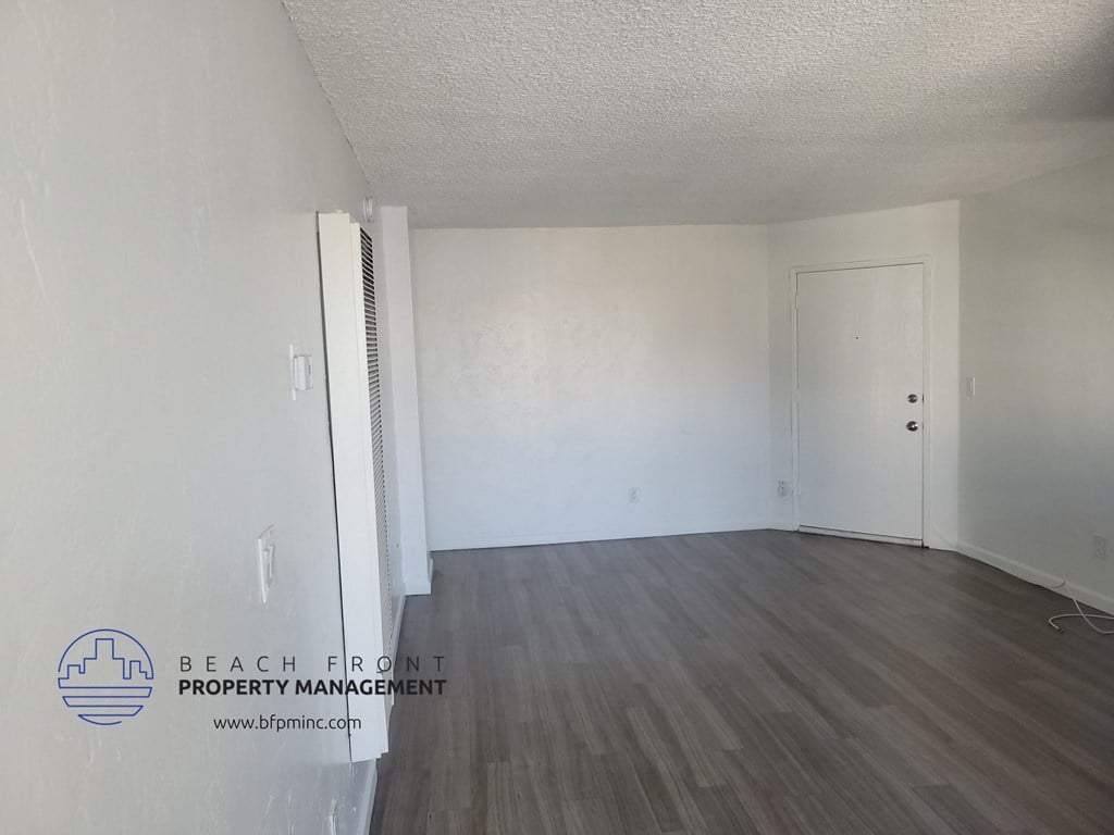 an empty living room with white walls and wood flooring