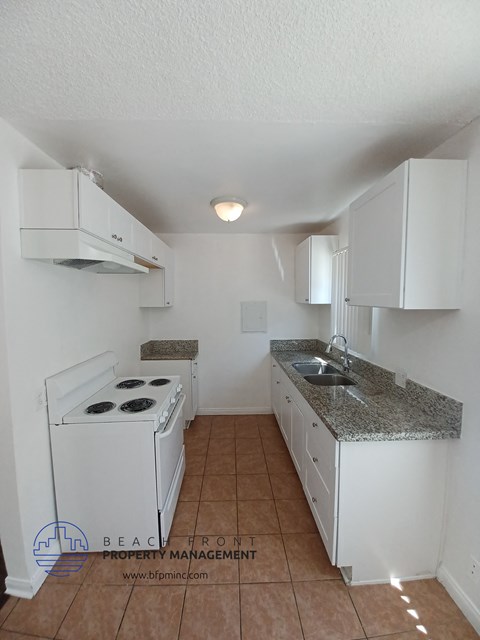 a kitchen with white cabinets and a stove and a sink