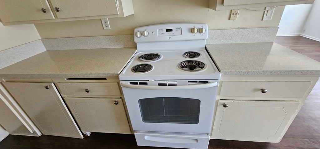 a kitchen with white cabinets and a white stove top oven