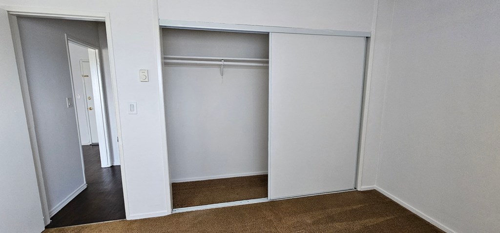 an empty closet in a bedroom with a door open