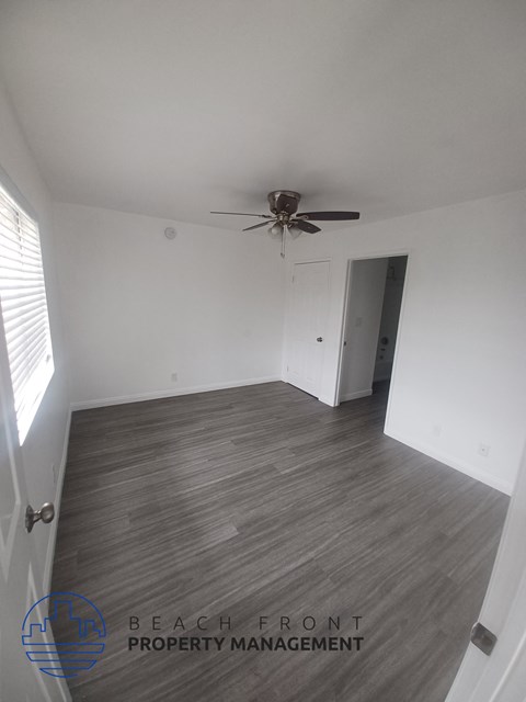 a living room with wood flooring and a ceiling fan