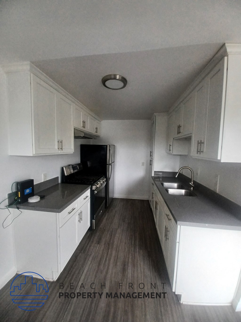 a small kitchen with white cabinets and a sink and a stove