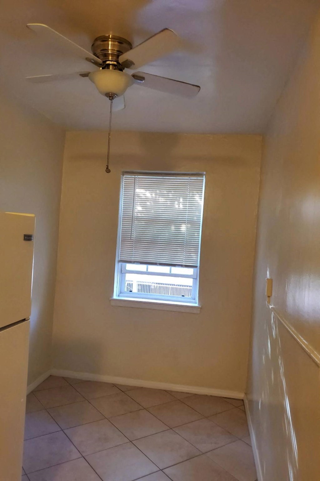 a kitchen with a ceiling fan and a window