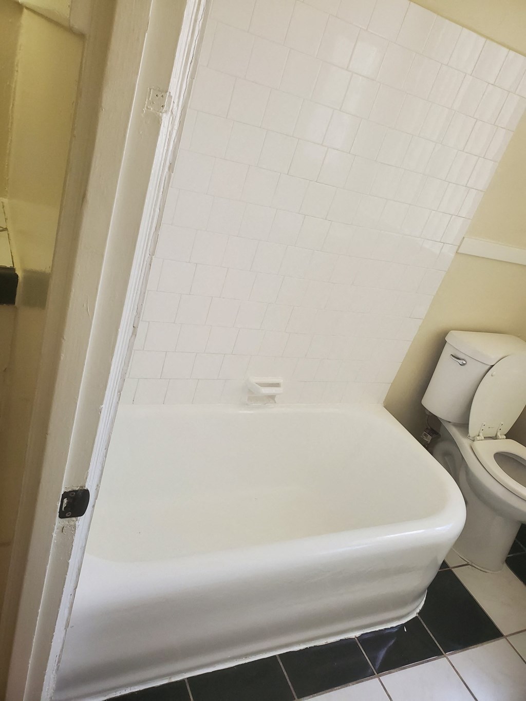 a bathroom with a white tub and a toilet