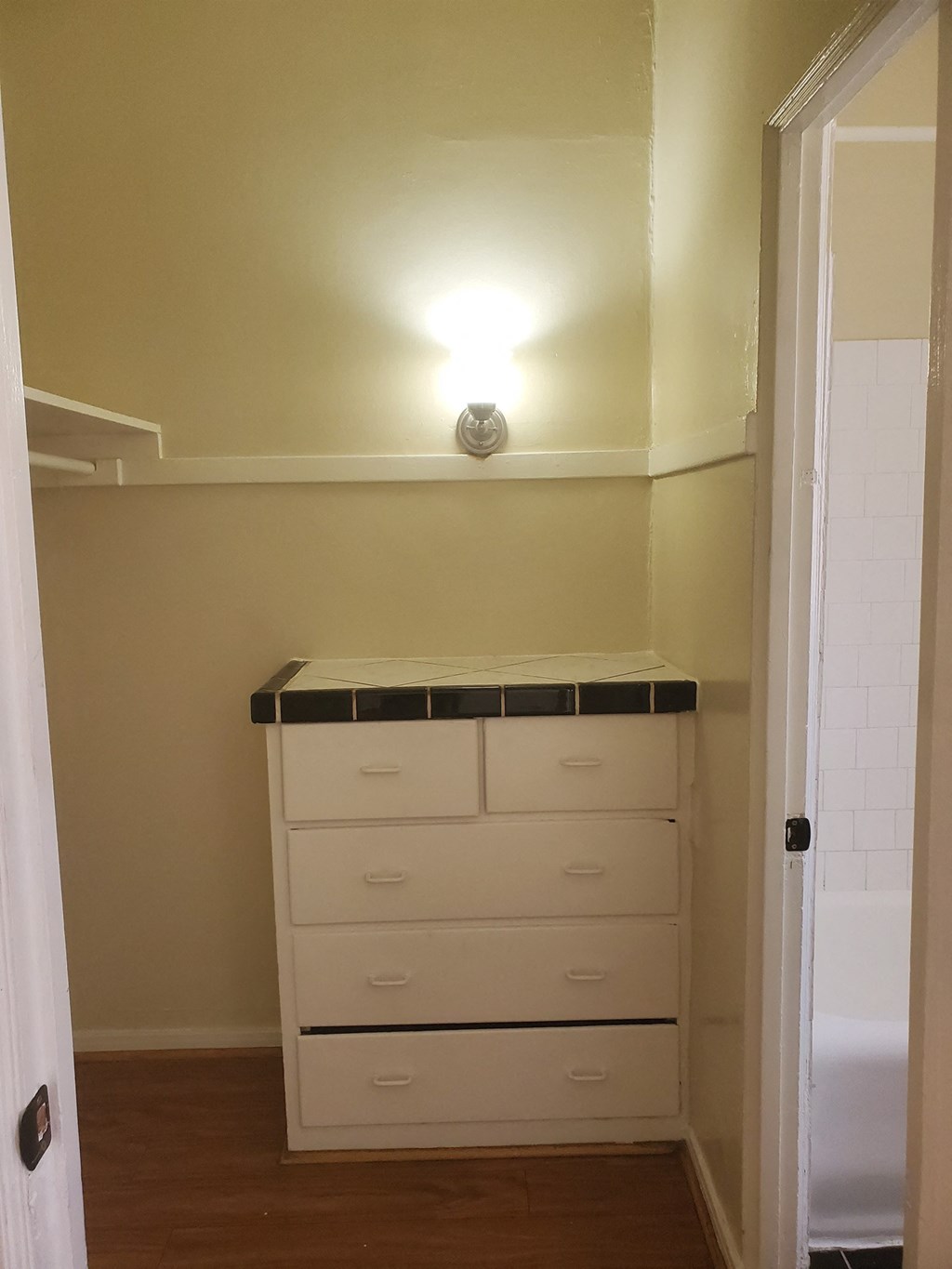 a closet with white drawers and a light on the ceiling
