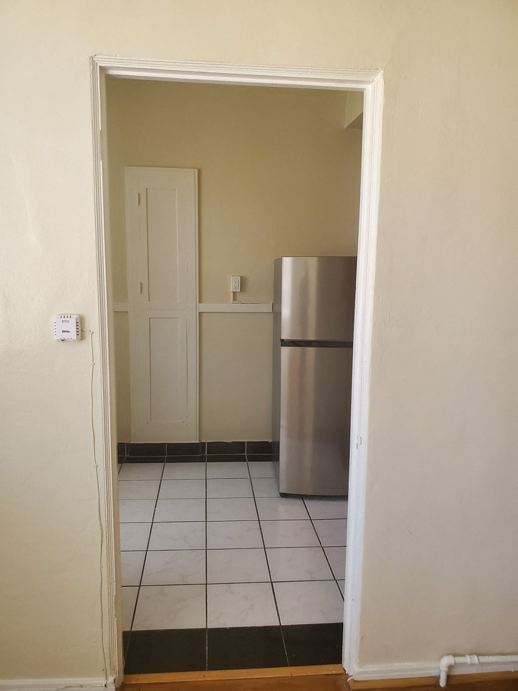 an empty room with a refrigerator in it