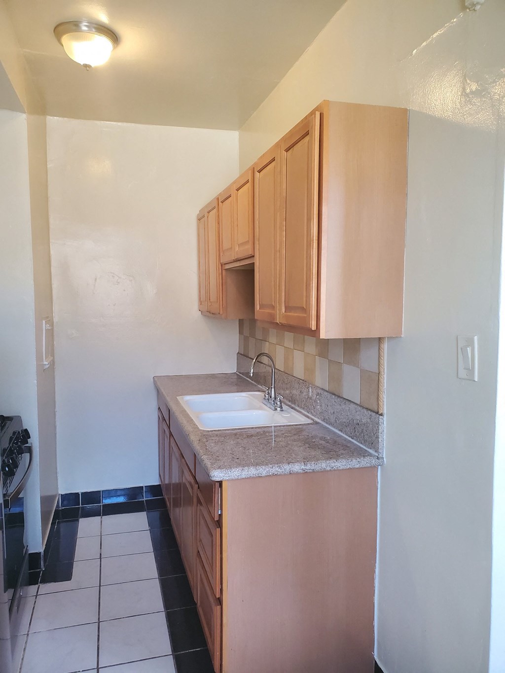 an empty kitchen with wooden cabinets and a sink