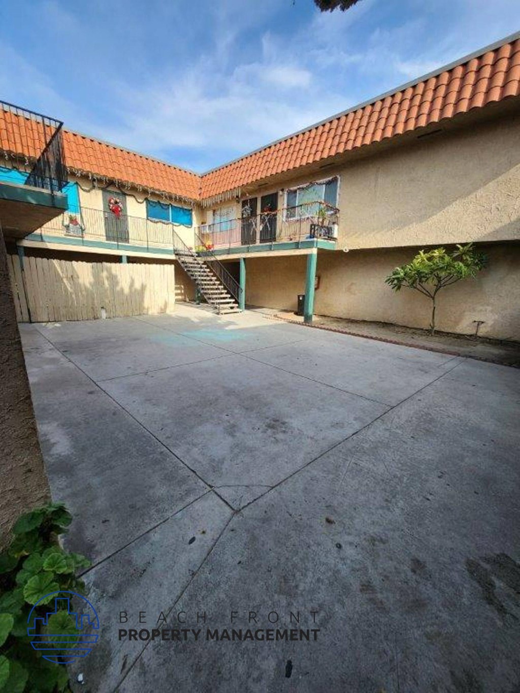 A courtyard with a tiled roof and a staircase leading to a balcony.