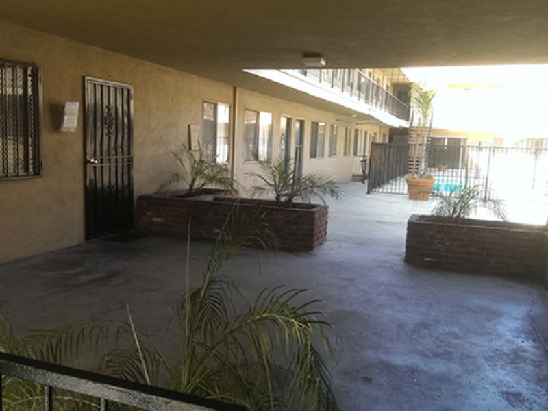 the lobby of a building with a concrete floor and plants