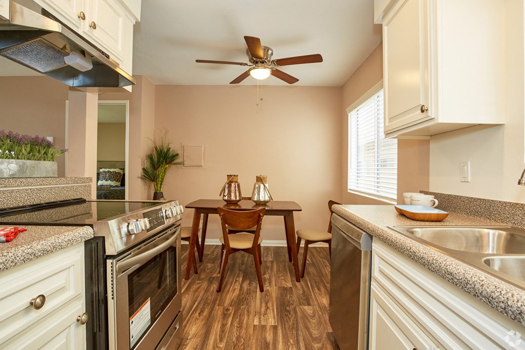 a kitchen with a table and chairs and a ceiling fan