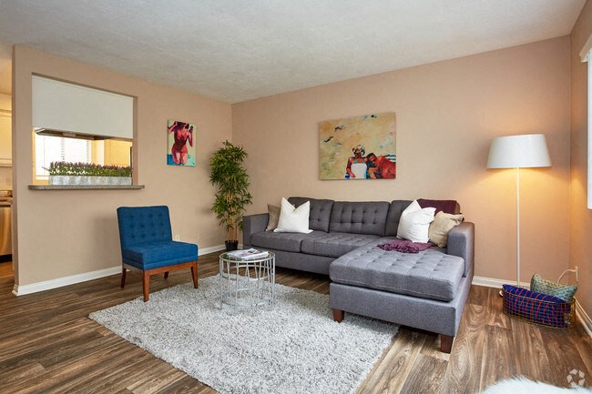 a living room with a gray couch and a blue chair